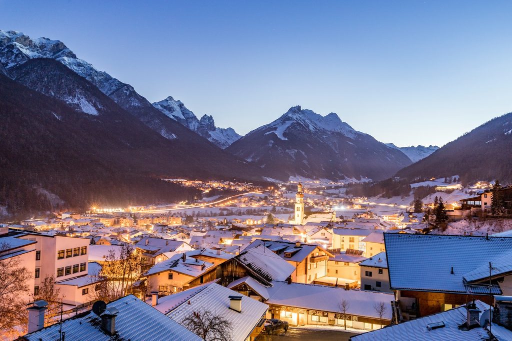 Snow-covered Alpine village surrounded by mountains during a cozy November escape in Europe